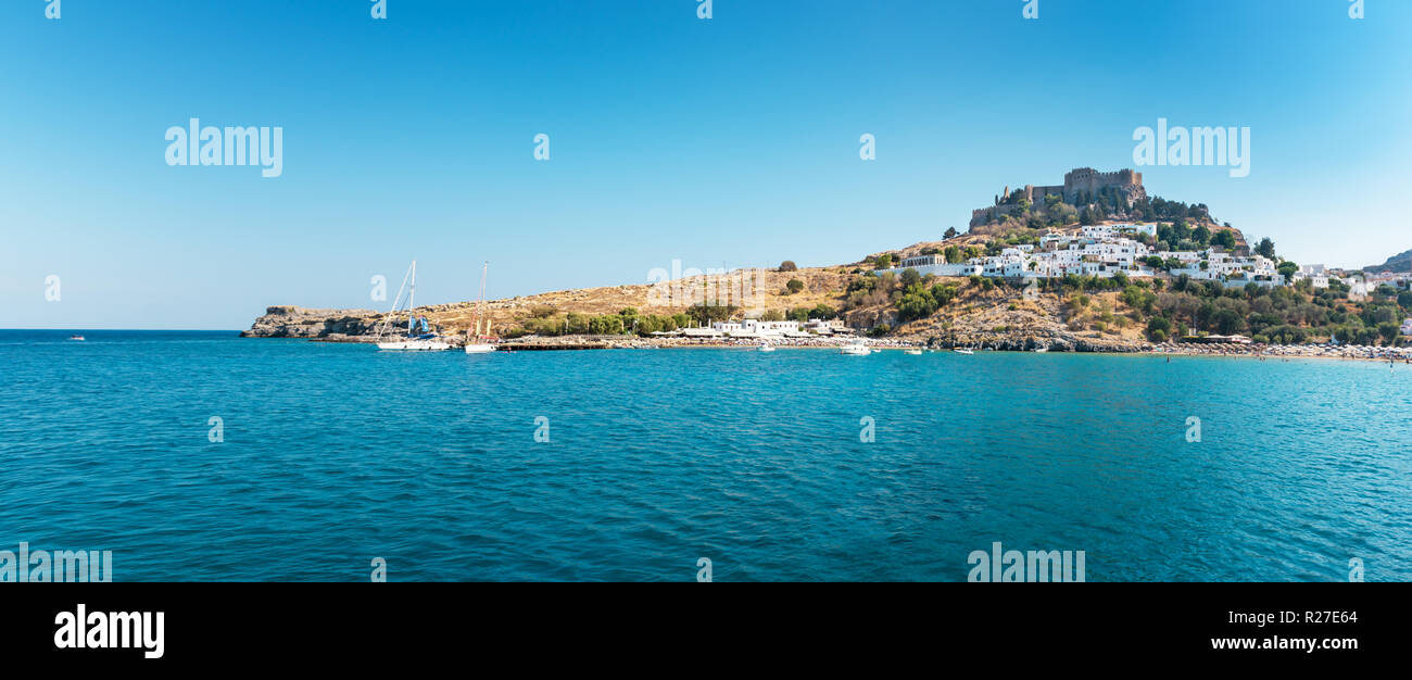 Vue sur plage de sable fin dans la baie de Lindos, Acropole en arrière-plan (Rhodes, Grèce) Banque D'Images