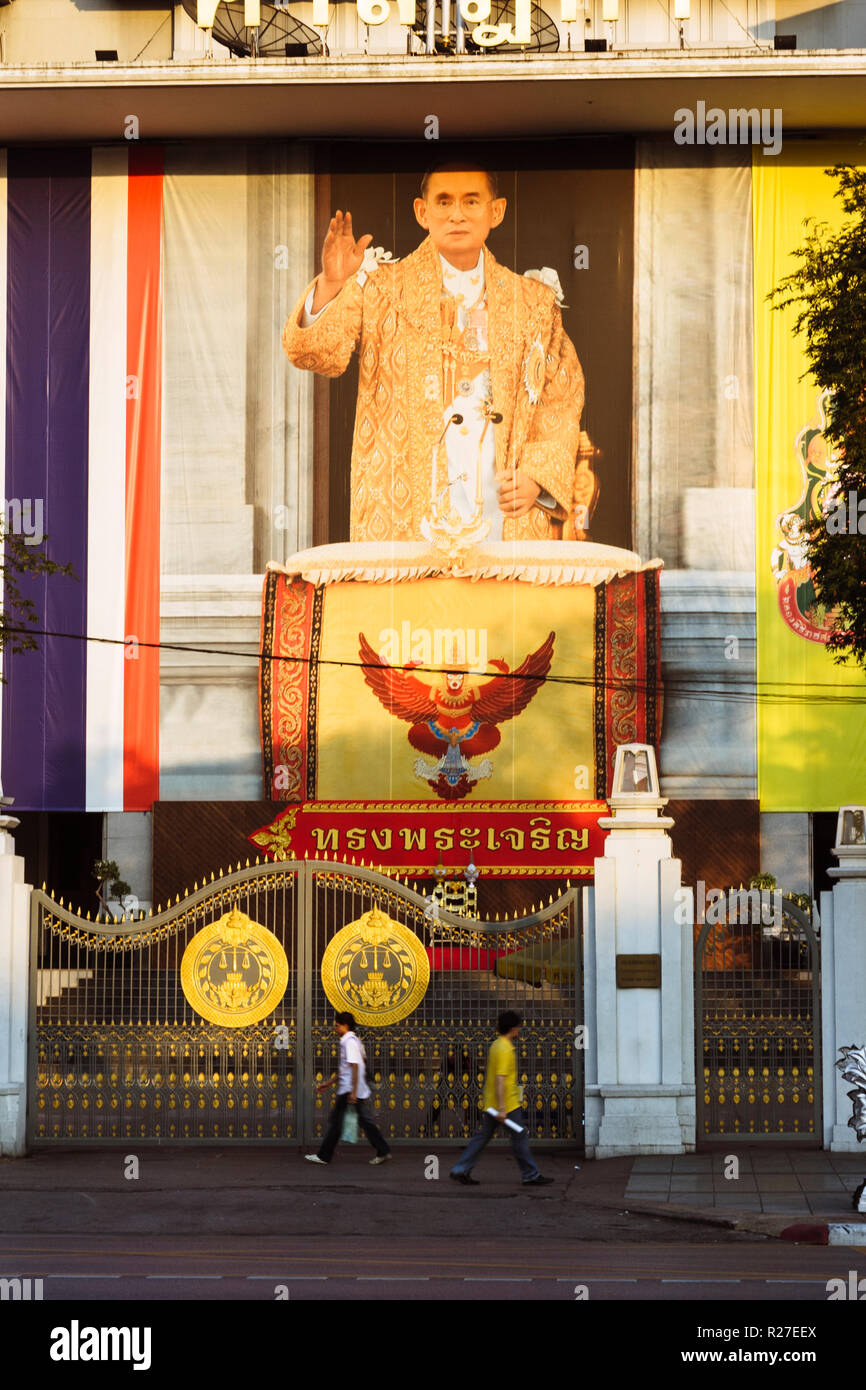Bangkok, Thaïlande : les gens passent devant un immense portrait du roi Bhumibol Adulyadej en centre-ville de Bangkok. Banque D'Images