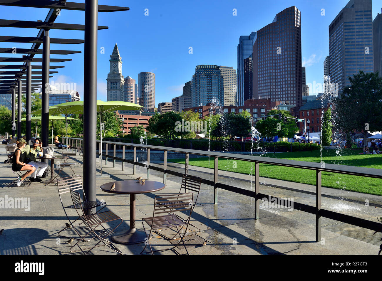 Ouvrir plaza sur Rose Kennedy Greenway avec tables et chaises et les immeubles de grande hauteur de Boston financial district derrière Banque D'Images