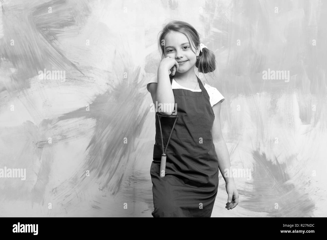 Enfant dans l'aire de cuisson. Avec l'enfant Chef de la pomme de terre pour piler. L'enfance et l'éducation. La cuisson à l'outil de cuisine. Petite fille sur fond coloré. Banque D'Images