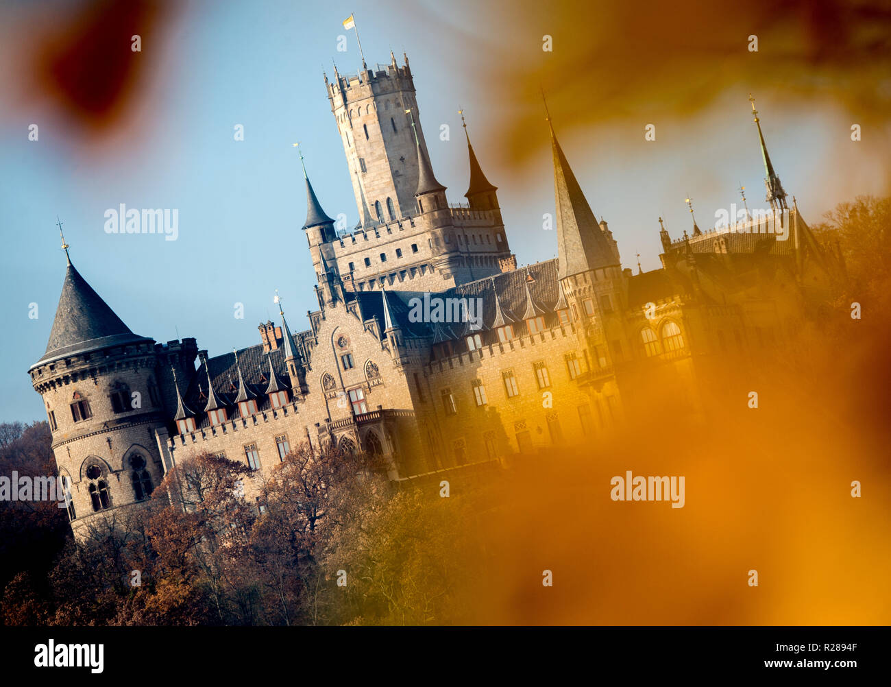 Nordstemmen, Allemagne. 17 novembre, 2018. Château de Marienburg est baignée d'une lumière chaude par le soleil, tandis que les feuilles d'automne se suspendre à un arbre. Credit : Hauke-Christian Dittrich/dpa/Alamy Live News Banque D'Images