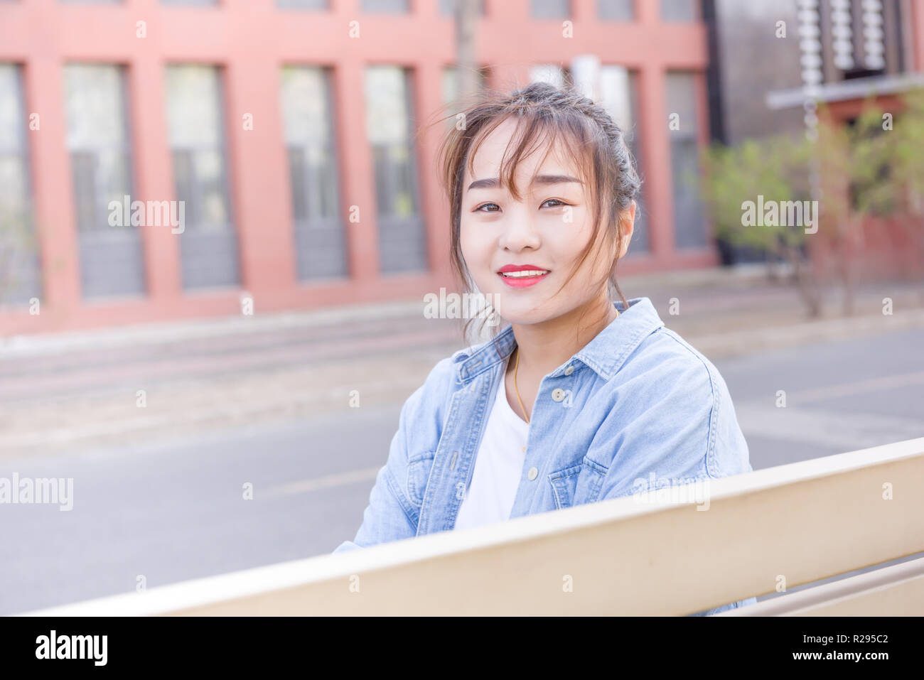 Jeune femme assise sur un banc à l'université Banque D'Images