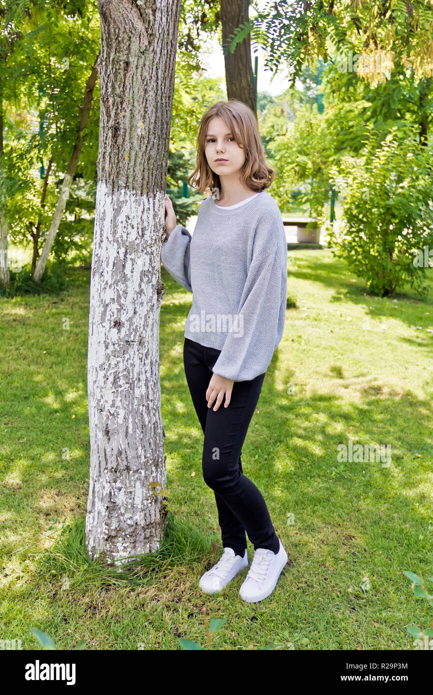 Belle fille de 14 ans s'appuyer sur l'arbre Photo Stock - Alamy