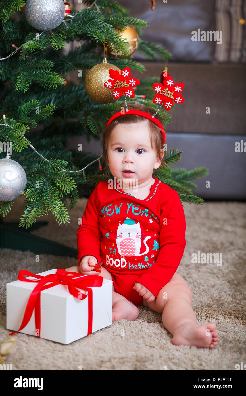 Beau petit bébé fête Noël. Les jours fériés. Bébé dans un costume de Noël cadeau avec Banque D'Images