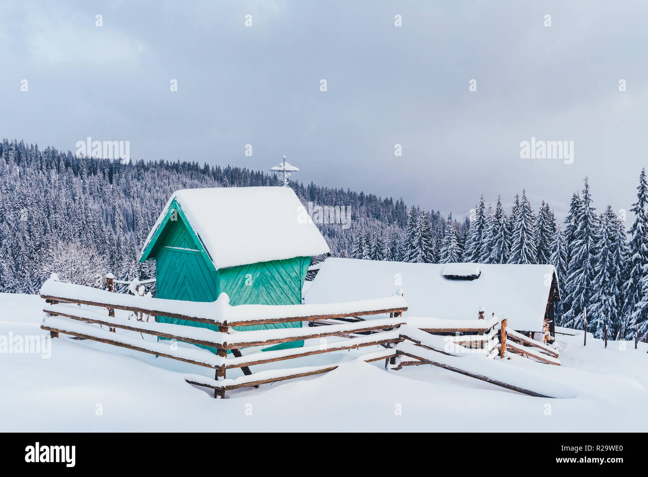 Paysage d'hiver fantastique avec la chapelle en bois vert et maison dans les montagnes enneigées. Concept de vacances de Noël. La montagne des Carpates, l'Ukraine, l'Europe Banque D'Images