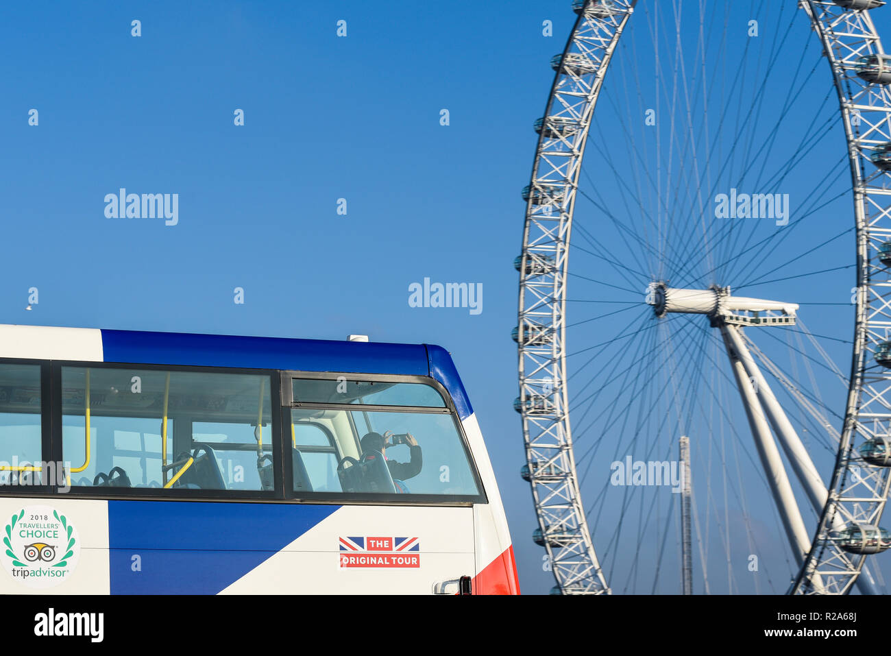 Un touriste sur un bus de tournée britannique en tenant un téléphone mobile téléphone appareil photo photographie du London Eye, grande roue du millénaire. Tripadvisor, la tournée originale Banque D'Images