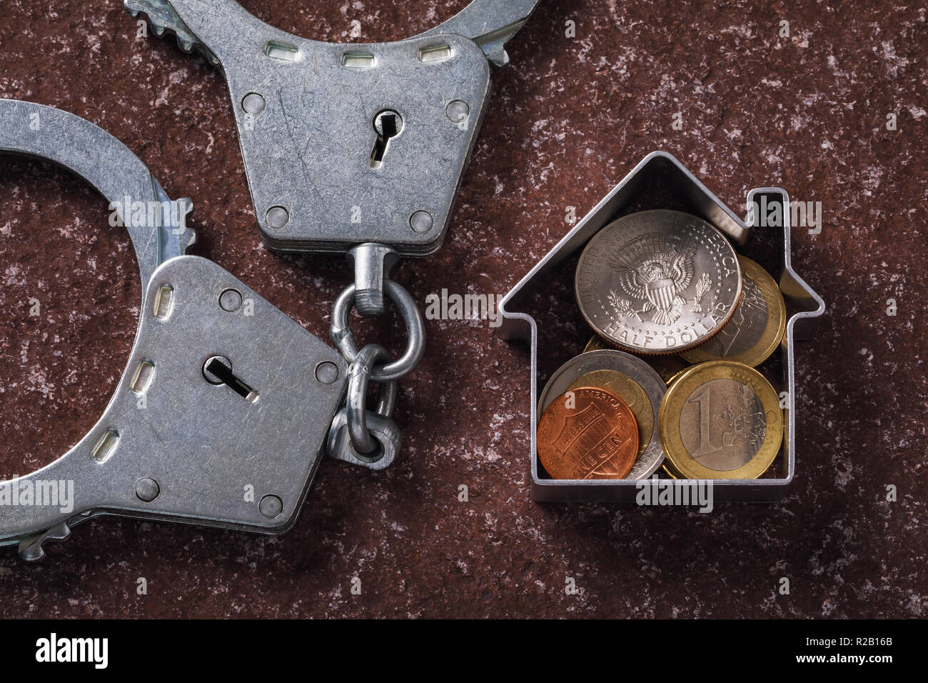 Les transactions financières dans le marché immobilier. Menottes et diverses pièces sur la surface en pierre Banque D'Images