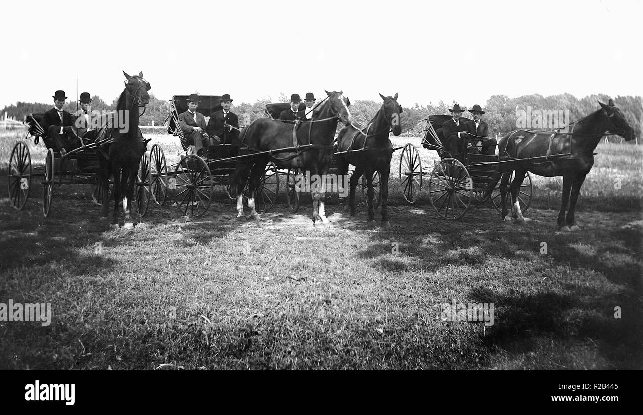 Dandy huit gars sont prêts à voyager dans leur cheval et buggies, ca. 1900. Banque D'Images