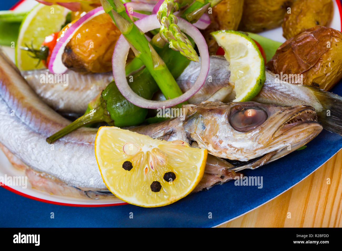 Mijotée dans du vin blanc avec du poisson Merlan bleu garnir des pommes de  terre au four et petits pois frais Photo Stock - Alamy