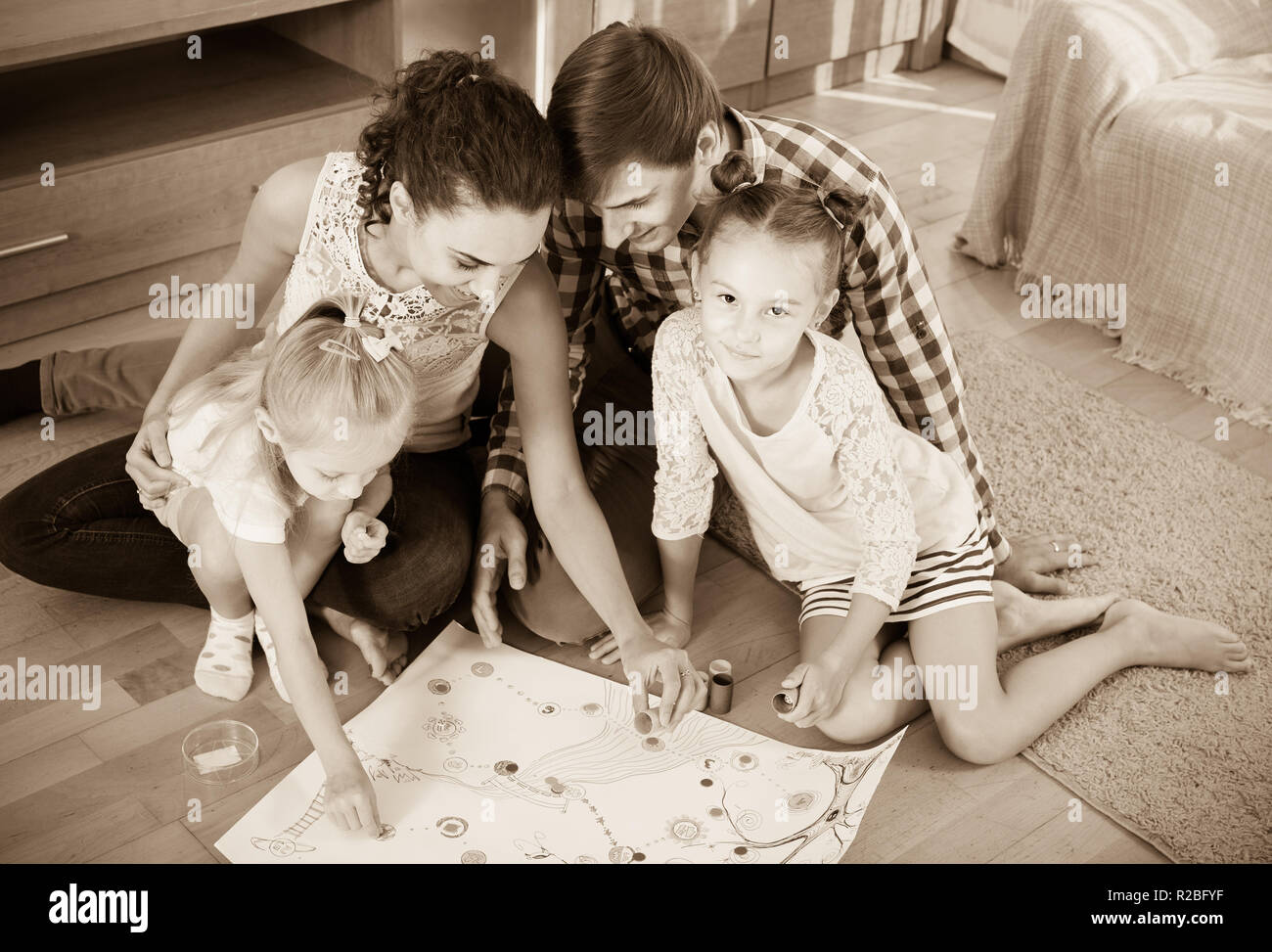 Famille heureuse de jouer au jeu de quatre Banque D'Images