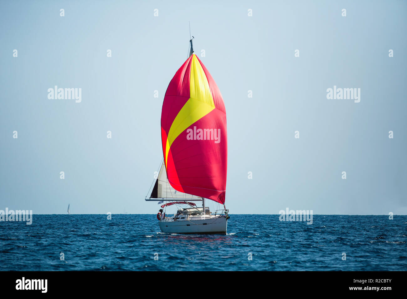 Yacht de luxe avec red sails à régate. La Voile dans le vent à travers les vagues à la mer. Banque D'Images