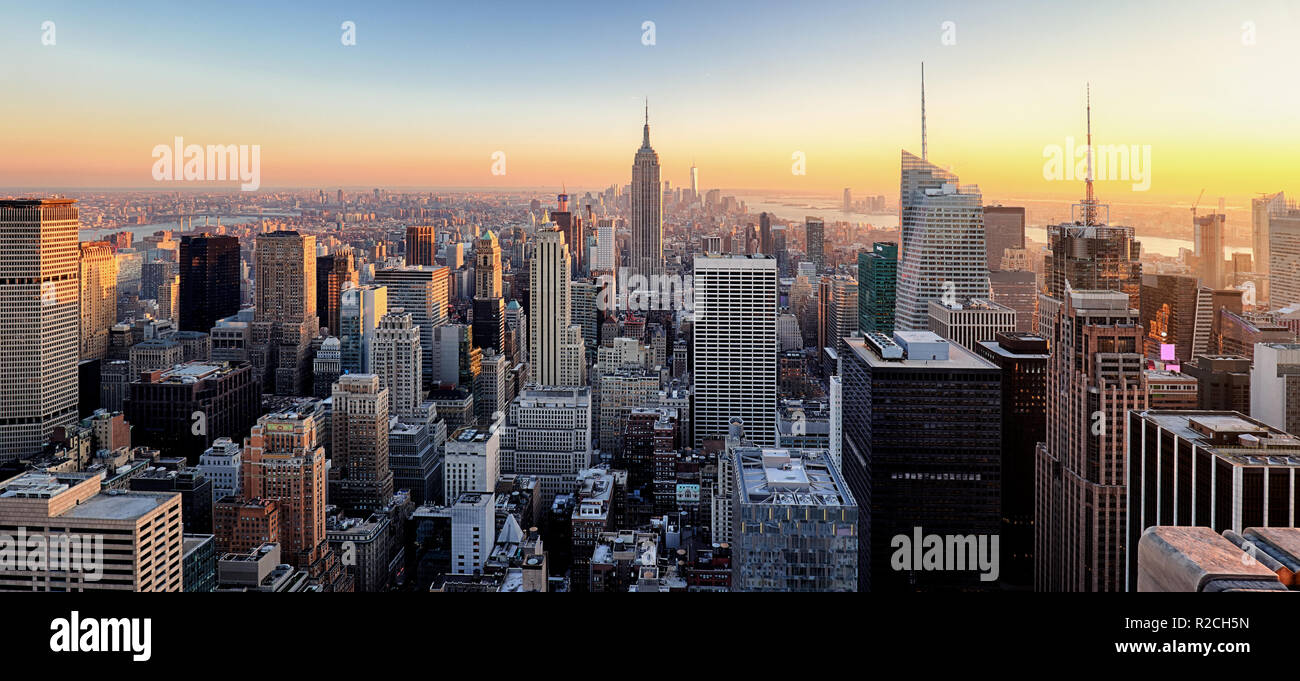 La ville de New York. Le centre-ville de Manhattan avec l'Empire State Building illuminé et gratte-ciel au coucher du soleil. Banque D'Images
