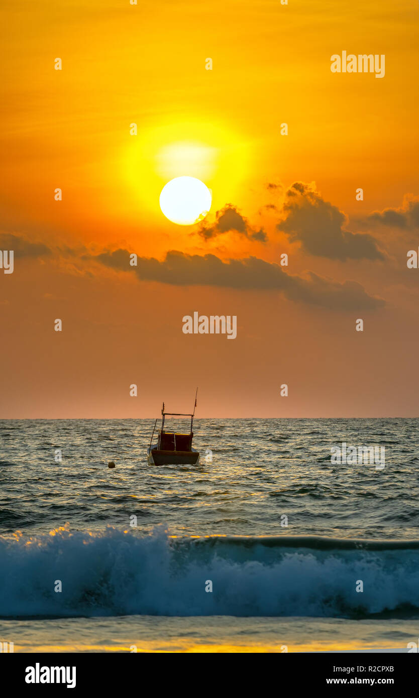 Belle scène de plage le matin quand le soleil se lève à côté du bateau de pêche des pêcheurs comme accueillant nouvelle journée intéressante. Banque D'Images