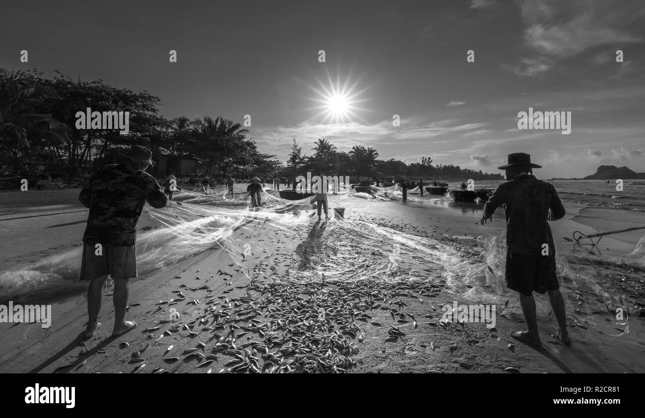 Les pêcheurs font du filet de pêche après avoir pêché comme moyen de vivre dans le village de pêche côtier. C'est un travail acharné, mais beaucoup de familles à Phan Thiet, Banque D'Images