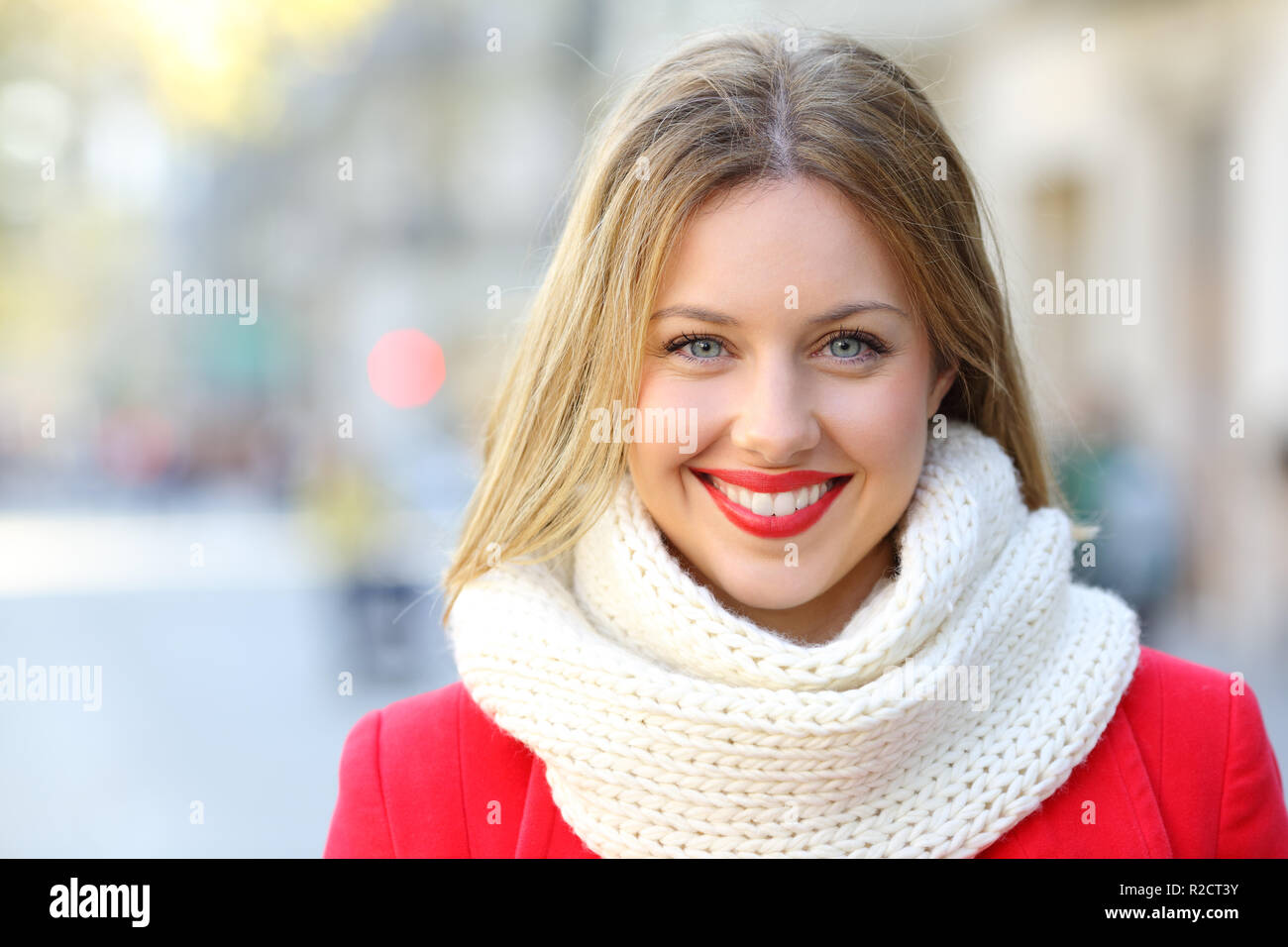 Vue avant portrait of a happy woman looking at camera dans la rue de la ville en hiver Banque D'Images