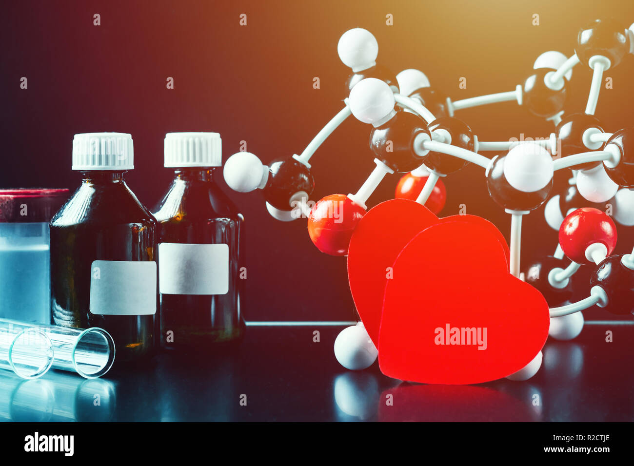 Deux coeurs en papier rouge et la structure moléculaire modèle sur fond noir. Concept de chimie d'amour Banque D'Images
