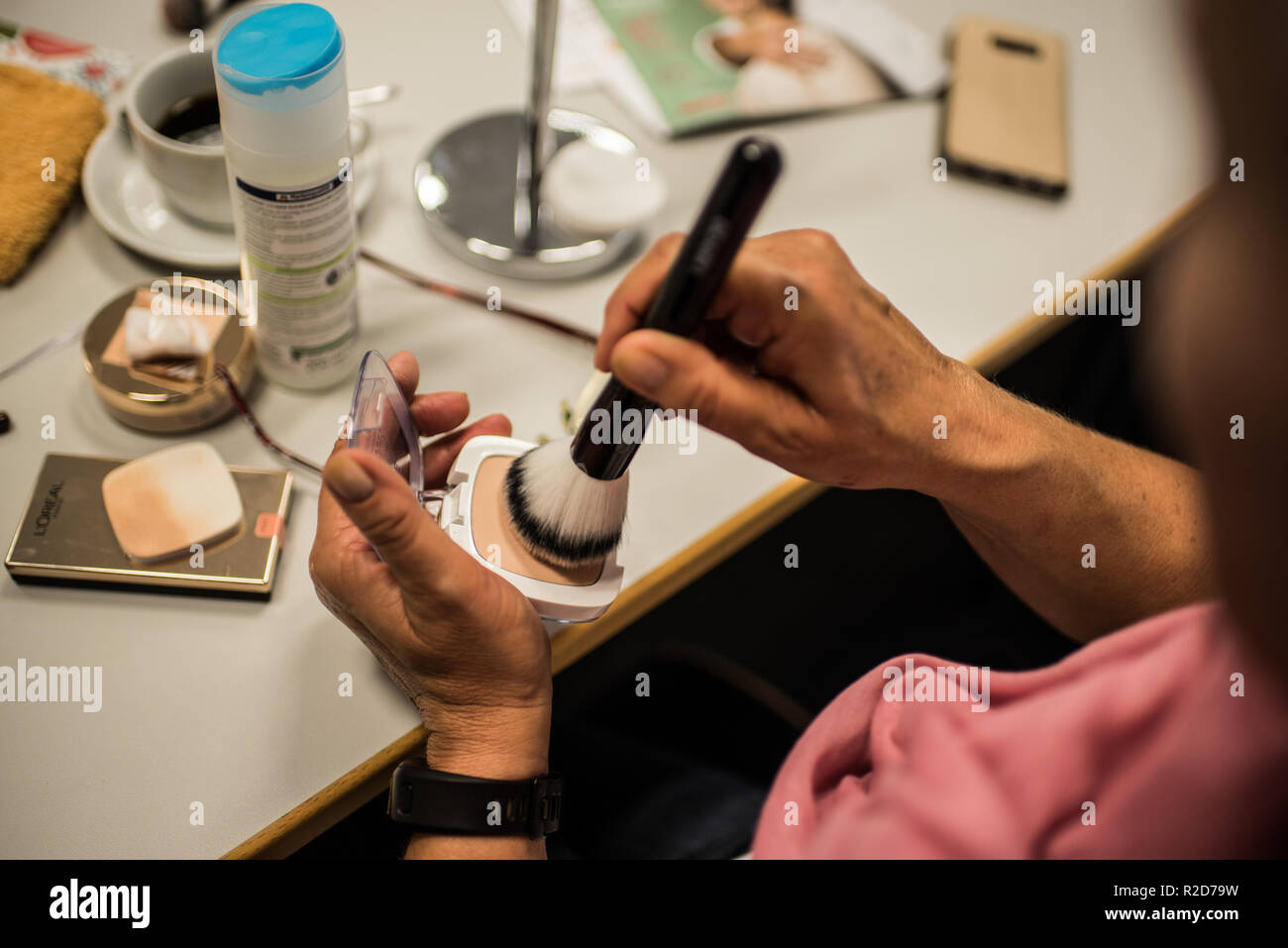 Mainz, Allemagne. 19 Oct, 2018. Une femme souffrant de cancer du sein s'applique aux produits cosmétiques un pinceau pendant un cours de maquillage. Le traitement du cancer par chimiothérapie ou radiothérapie traitement peut changer radicalement l'apparence de la peau avec la perte de cheveux, perte de cils et sourcils ou des irritations de la peau. Le fichier de donneurs de moelle osseuse, Allemand (DKMS) propose pour les femmes concernées en particulier sur il a coordonné les cours de mise à niveau. (Pour 'dpa avec make-up pinceau et la peinture contre les traces de cancer' à partir de 19.11.2018) Crédit : Andreas Arnold/dpa/Alamy Live News Banque D'Images