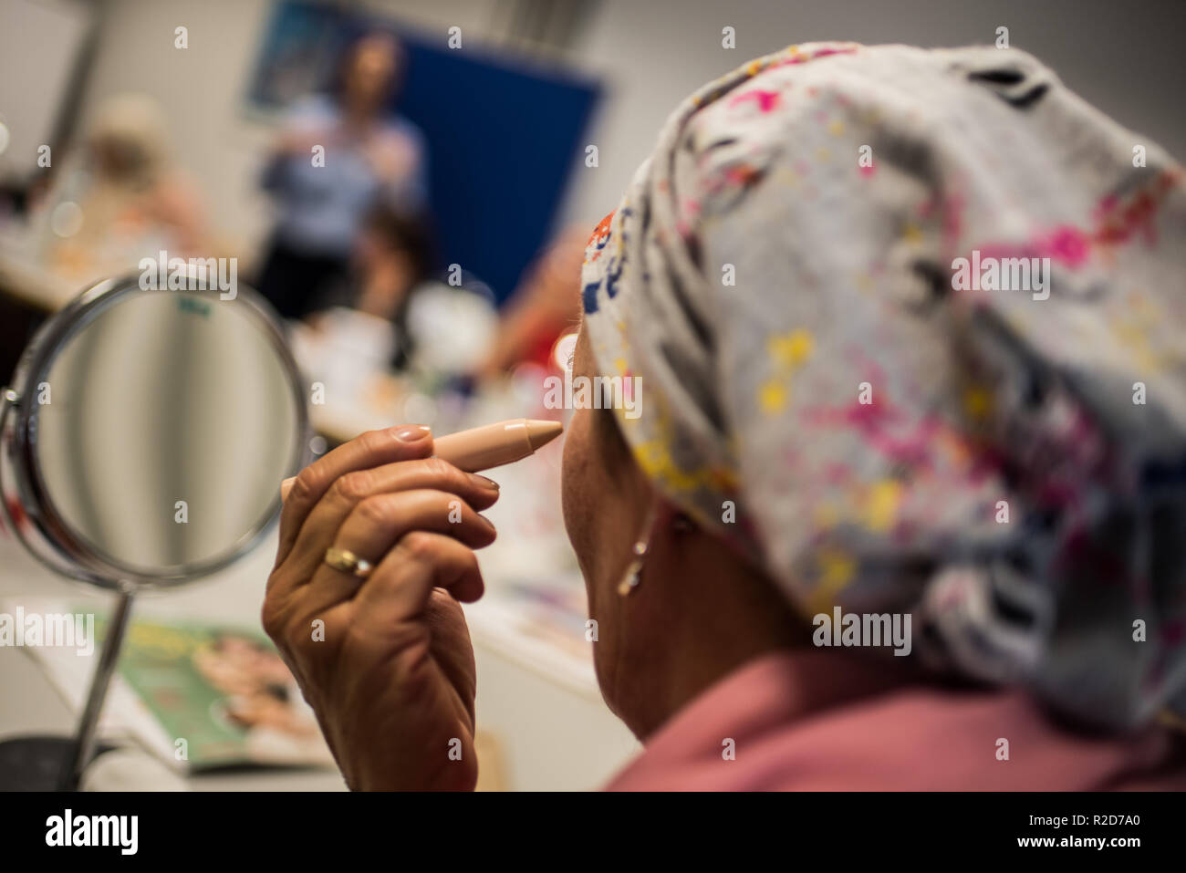 Mainz, Allemagne. 19 Oct, 2018. Une femme avec le cancer utilise un bâton de masquage dans son maquillage classe. Le traitement du cancer par chimiothérapie ou radiothérapie traitement peut changer radicalement l'apparence de la peau avec la perte de cheveux, perte de cils et sourcils ou des irritations de la peau. Le fichier de donneurs de moelle osseuse, Allemand (DKMS) propose pour les femmes concernées en particulier sur il a coordonné les cours de mise à niveau. (Pour 'dpa avec make-up pinceau et la peinture contre les traces de cancer' à partir de 19.11.2018) Crédit : Andreas Arnold/dpa/Alamy Live News Banque D'Images