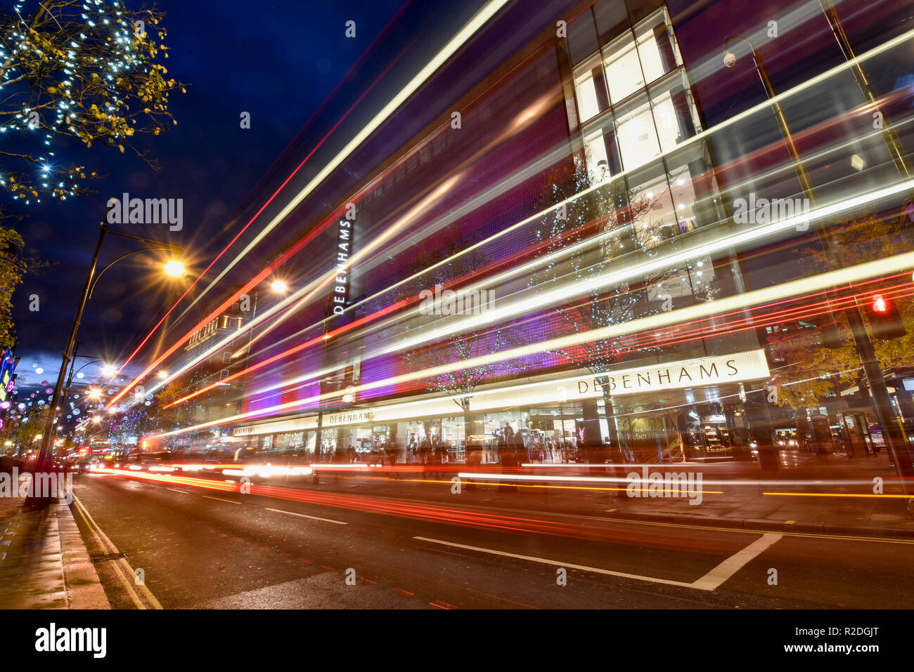 London, UK 19 novembre 2018. Le trafic passe par les lumières de fête et les décorations illuminant Debenhams magasin sur Oxford Street dans la capitale du West End. Les détaillants sont actuellement en train de préparer cette semaine de vendredi noir et devra faire face à une forte concurrence de leurs rivaux en ligne. Crédit : Stephen Chung / Alamy Live News Banque D'Images