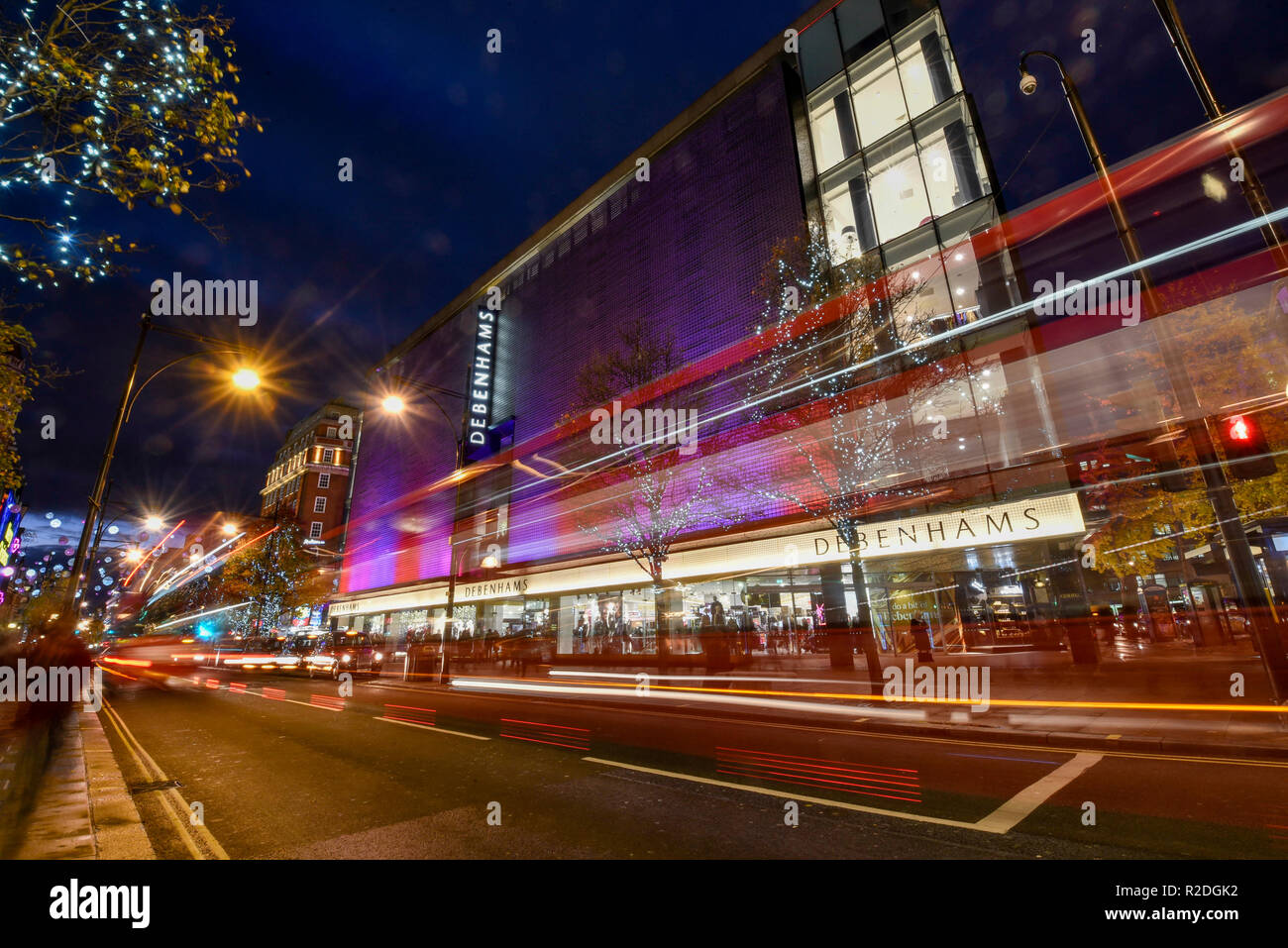 London, UK 19 novembre 2018. Le trafic passe par les lumières de fête et les décorations illuminant Debenhams magasin sur Oxford Street dans la capitale du West End. Les détaillants sont actuellement en train de préparer cette semaine de vendredi noir et devra faire face à une forte concurrence de leurs rivaux en ligne. Crédit : Stephen Chung / Alamy Live News Banque D'Images