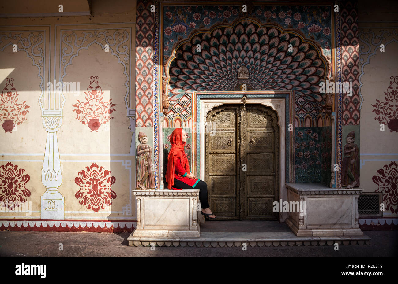 Femme au foulard rouge assis près de la porte de Lotus dans City Palace de Jaipur, Rajasthan, Inde Banque D'Images