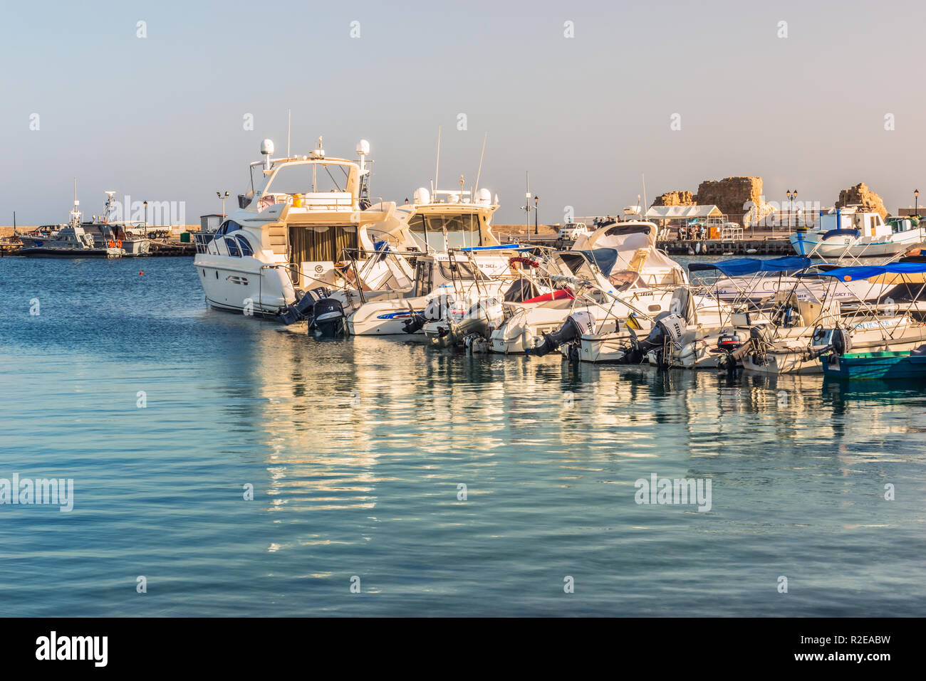 Paphos, Chypre - 20 septembre 2016 : Blanc yachts et bateaux sur le quai dans le port de Paphos, dans les rayons de soleil. Fragment de la ruine d'un ancie Banque D'Images