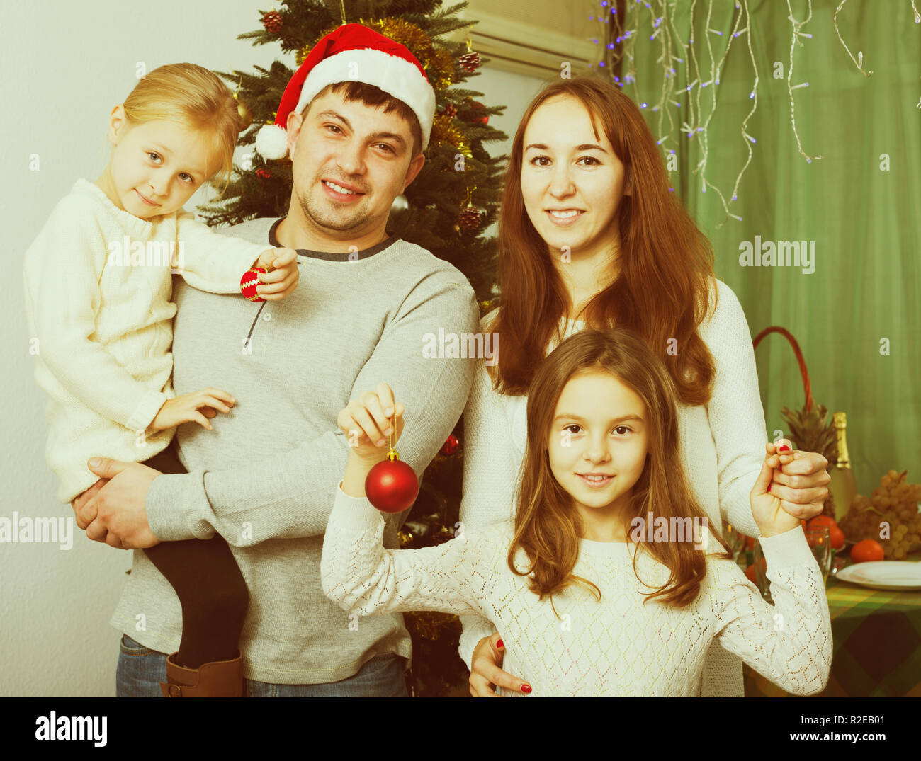 Famille de quatre joyeux à la maison avec l'arbre de Noël à la maison Banque D'Images