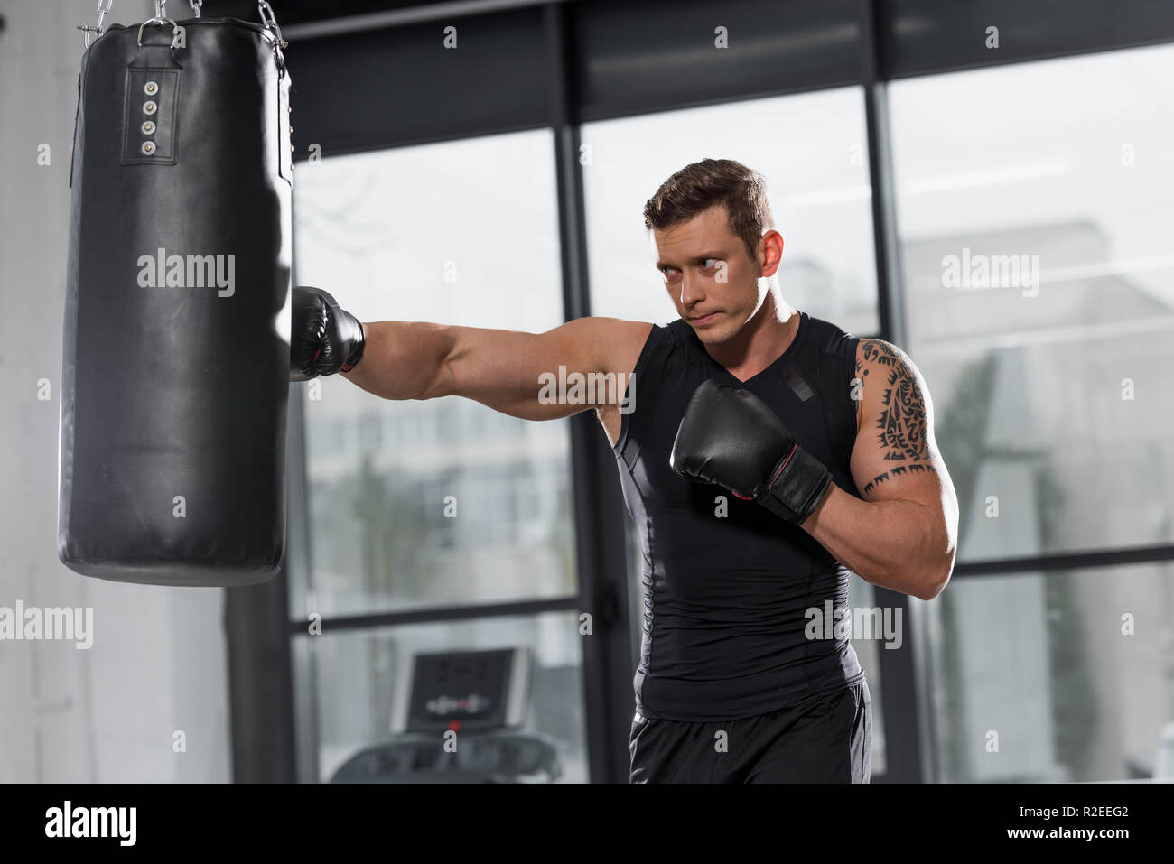 Beau boxer musculaire l'entraînement avec sac de boxe dans une salle de  sport Photo Stock - Alamy