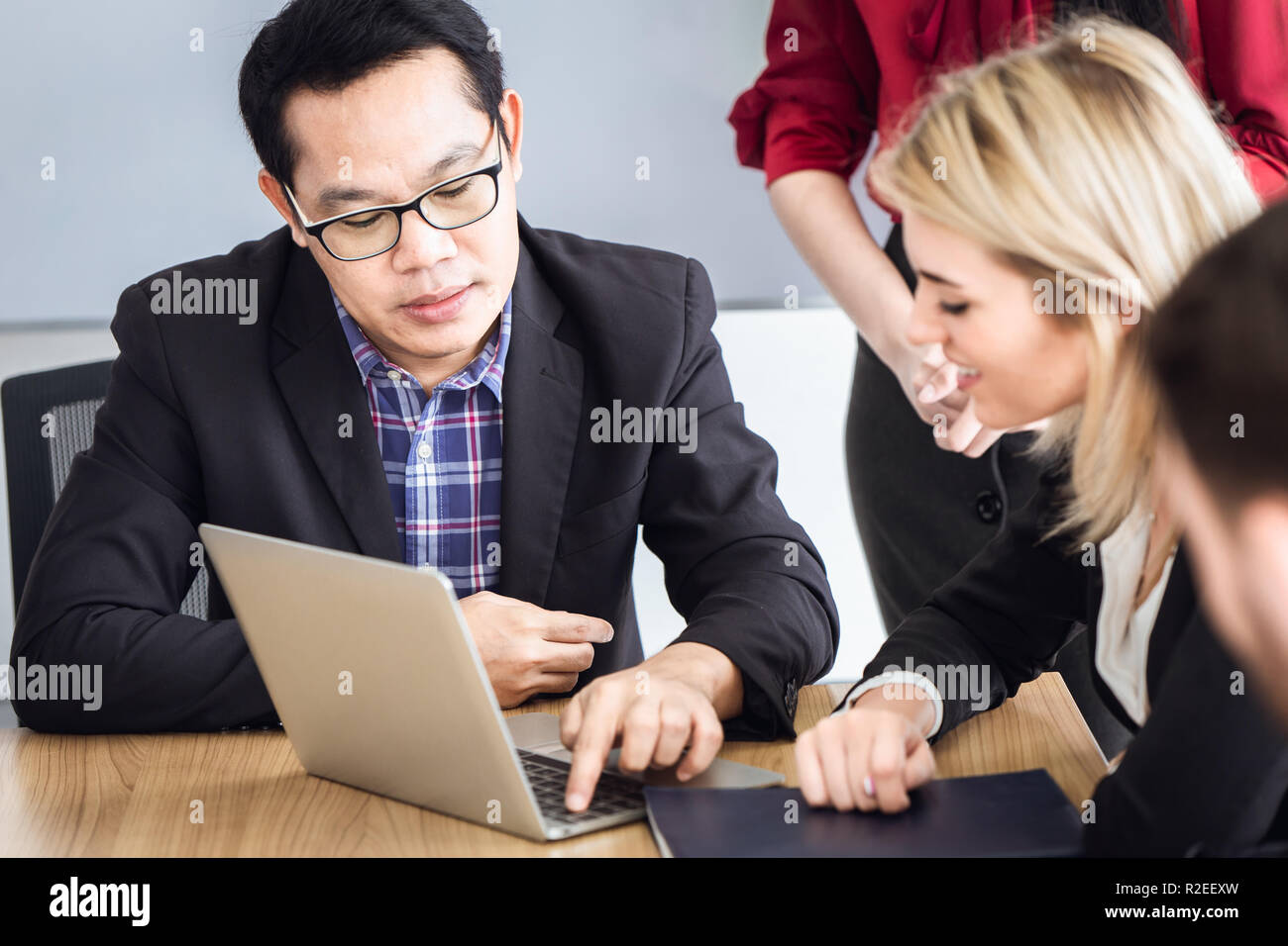 Look d'affaires à l'ordinateur portable dans la salle de réunion asiatique et caucasienne race mix. Banque D'Images