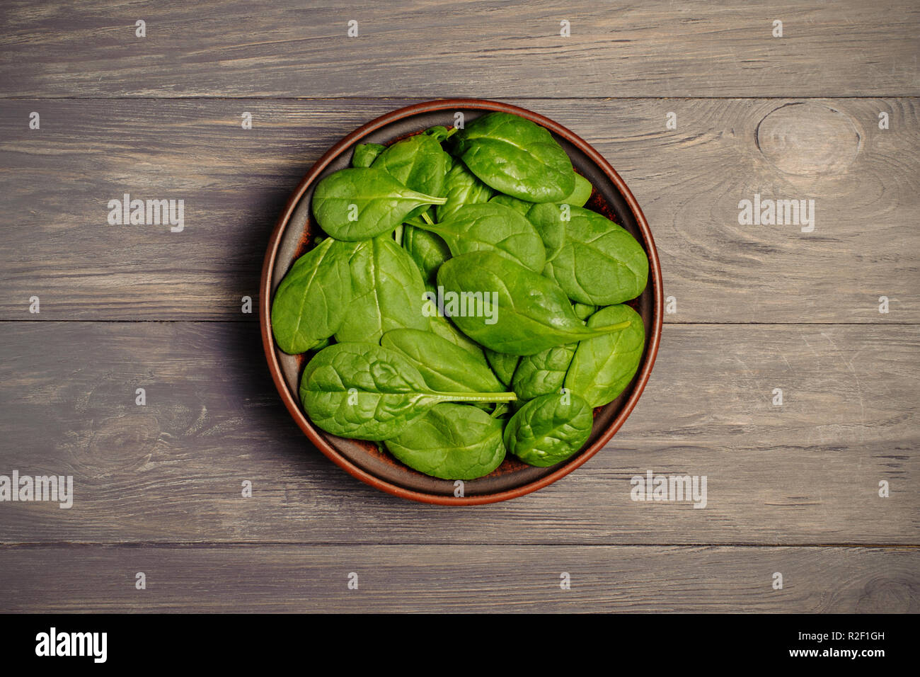 Les feuilles d'épinards vert brun en coupe sur table rustique . Les aliments biologiques.Vue de dessus.Le concept photo de poids perdu. Banque D'Images