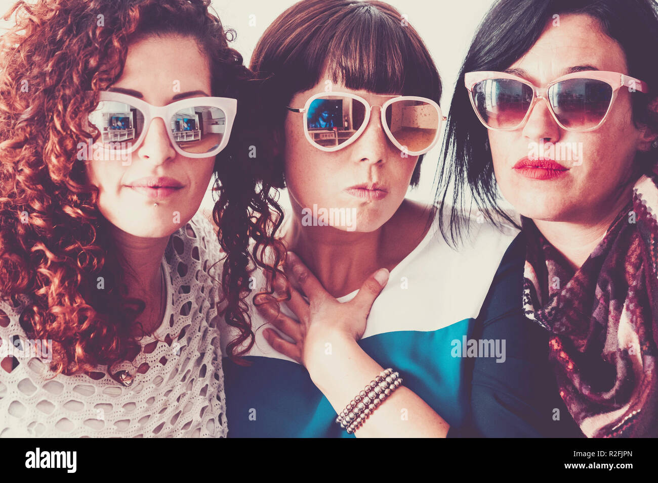 Fashion et tendance concept avec trois belles jeunes femmes portant des lunettes  de soleil ensemble dans des couleurs vintage filtre. mignon et nice people  having fun in style coloré Photo Stock -