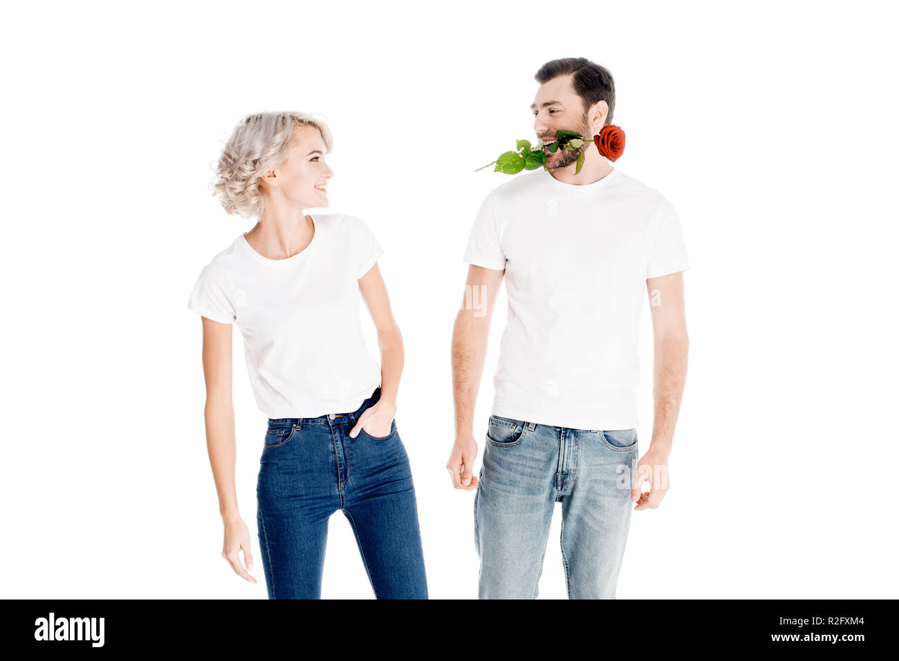 Beau couple alors que man holding fleur en bouche isolated on white Banque D'Images