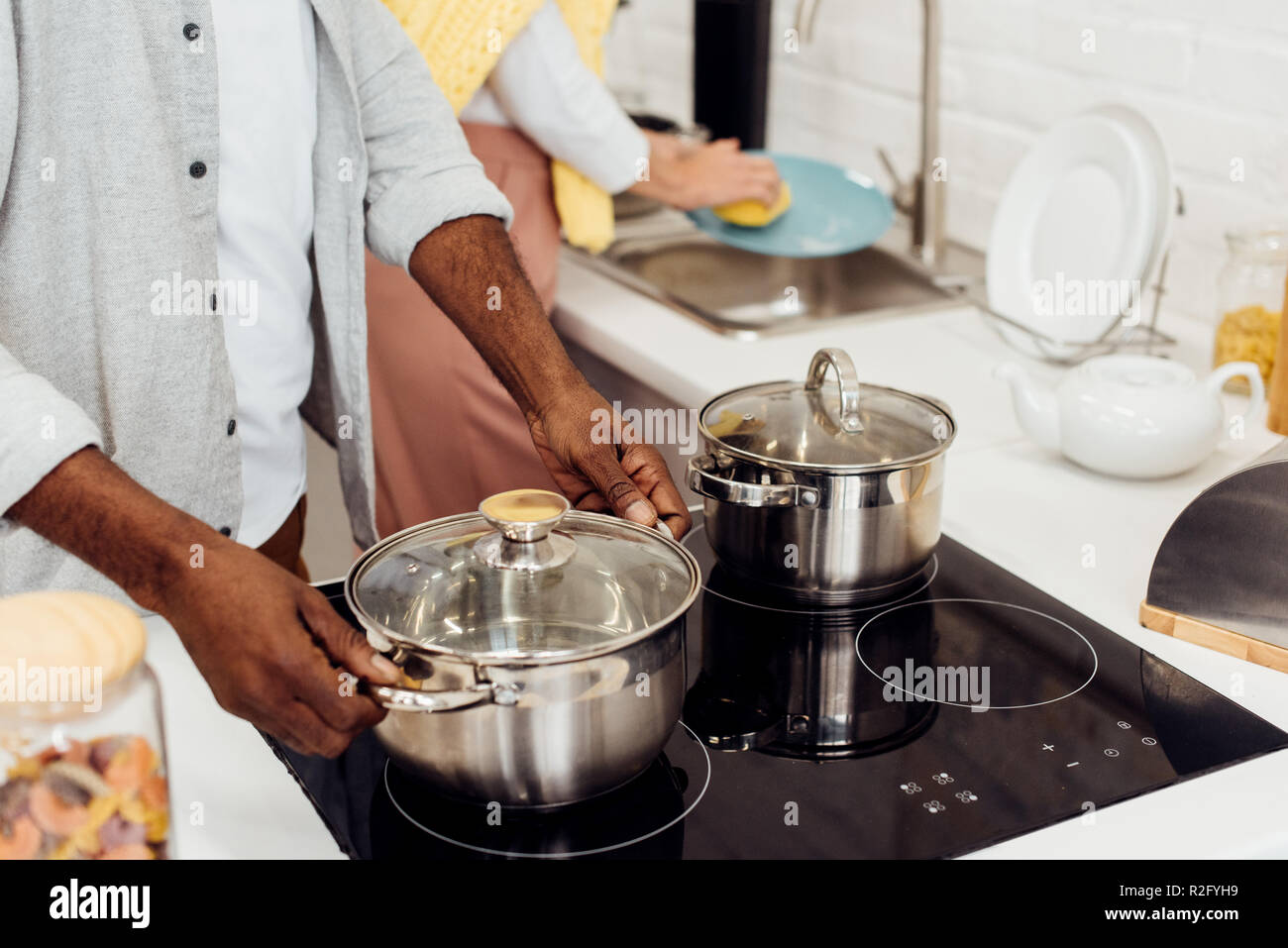 Close up of african american man holding pot alors que femme lave-vaisselle cuisine à Banque D'Images