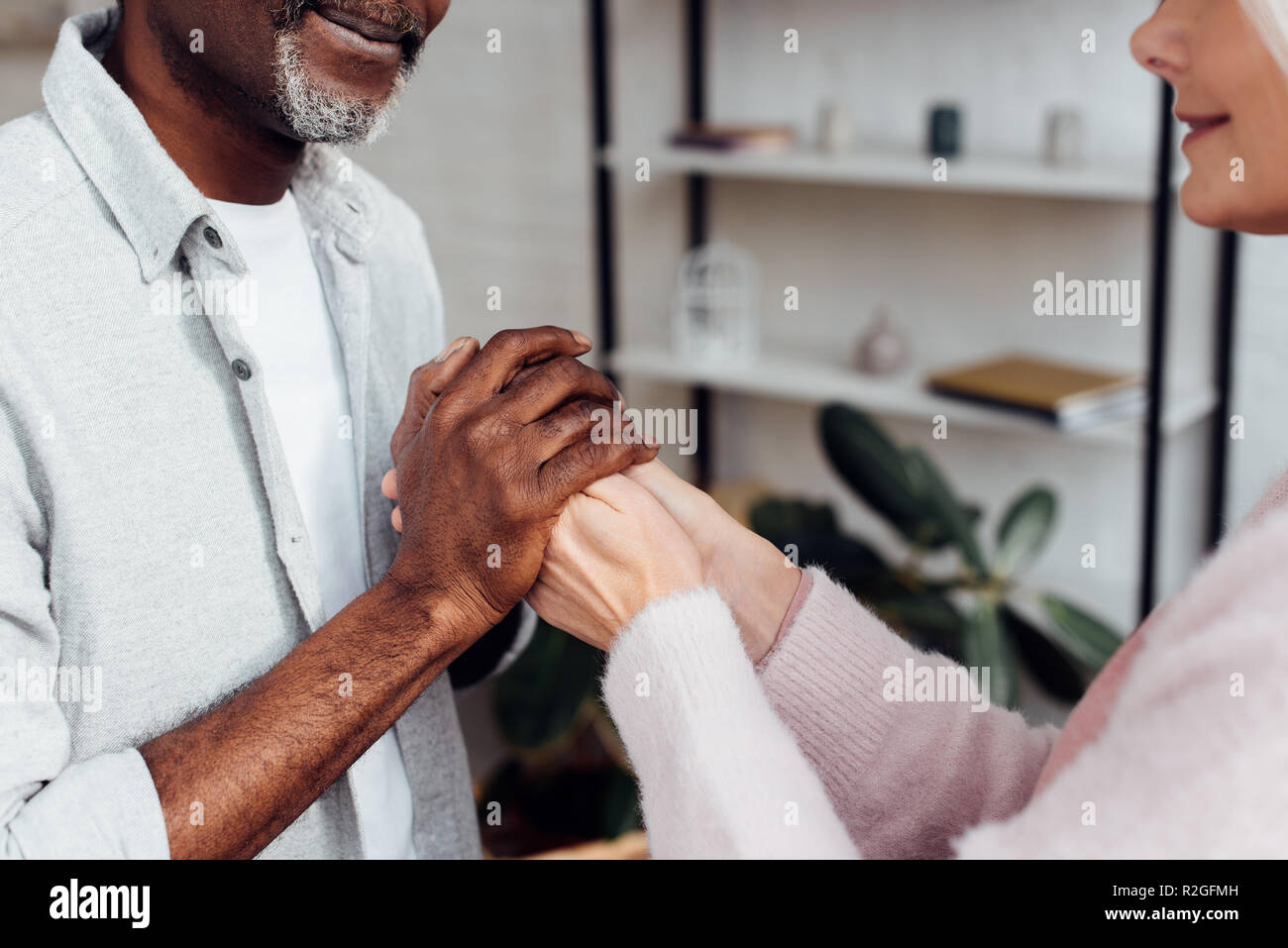 Close up of young woman and african american man holding hands together Banque D'Images