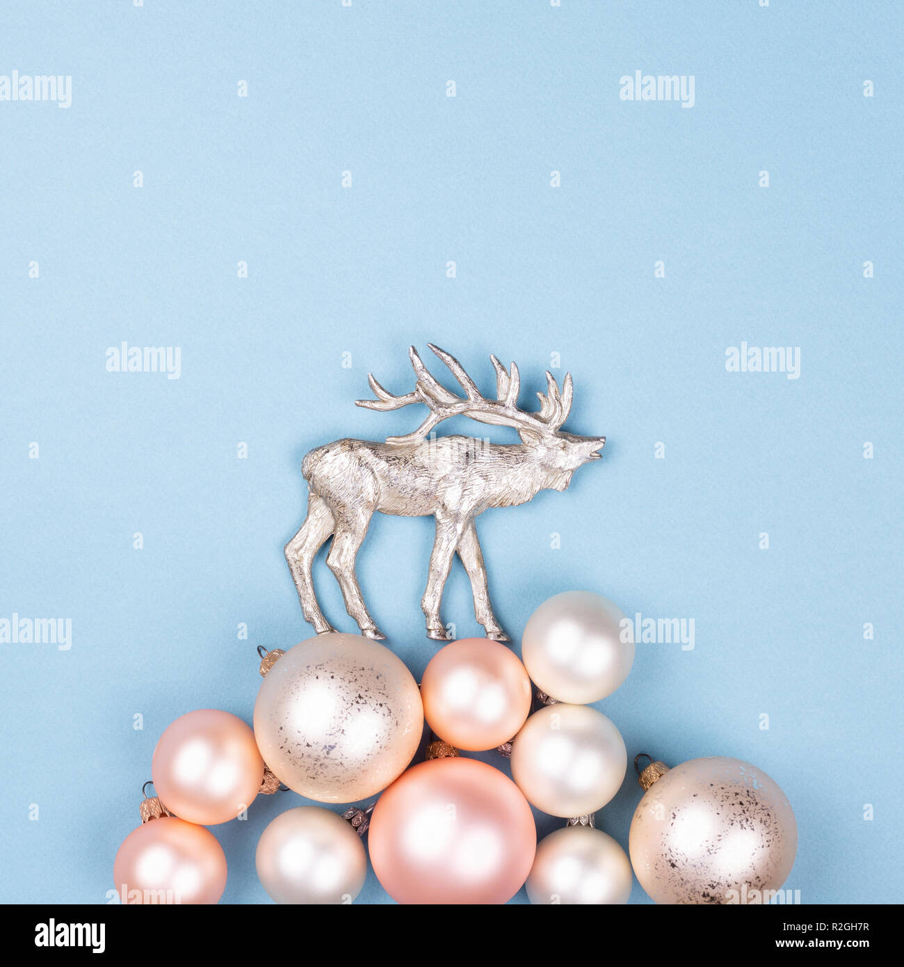 Composition de noël faites de boules de Noël et la figurine de rennes sur fond bleu. Concept de marche du renne sur le banc de neige. Carte de vacances de style minimal. Banque D'Images