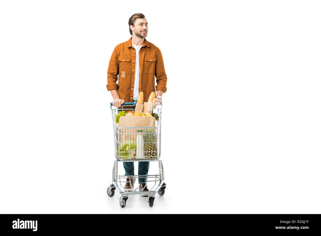 Handsome man carrying shopping trolley avec des produits dans des sacs en papier isolated on white Banque D'Images