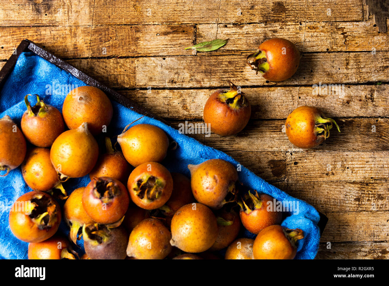 Medlars brutes sur une table en bois rustique vue supérieure Banque D'Images