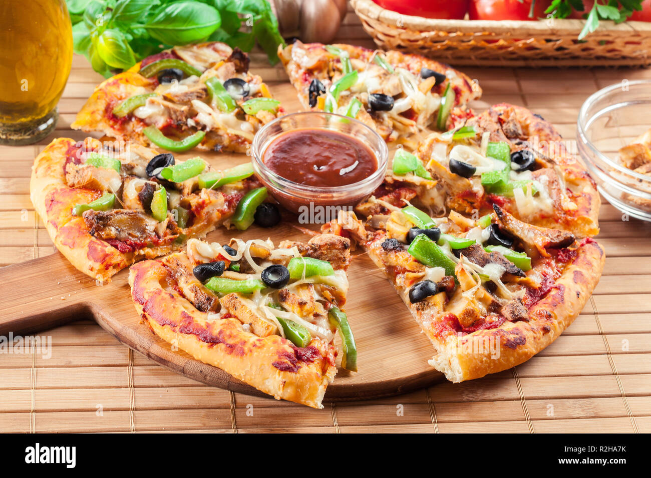 Pizza au poulet épicé avec des gyroscopes, le poivron vert, les olives et l'oignon on cutting board Banque D'Images