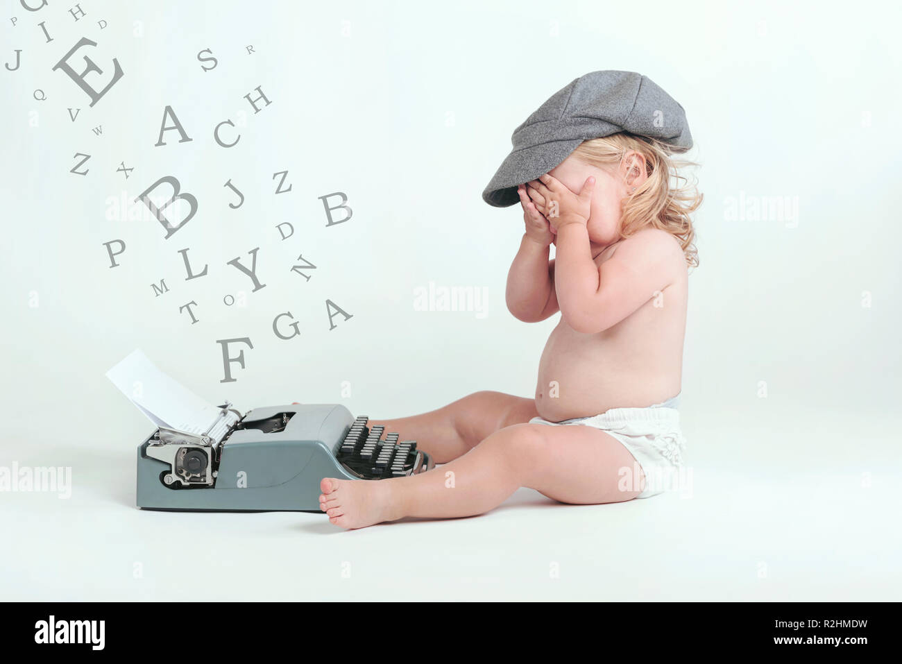 Taper avec un bébé vieille machine à écrire sur fond blanc Banque D'Images