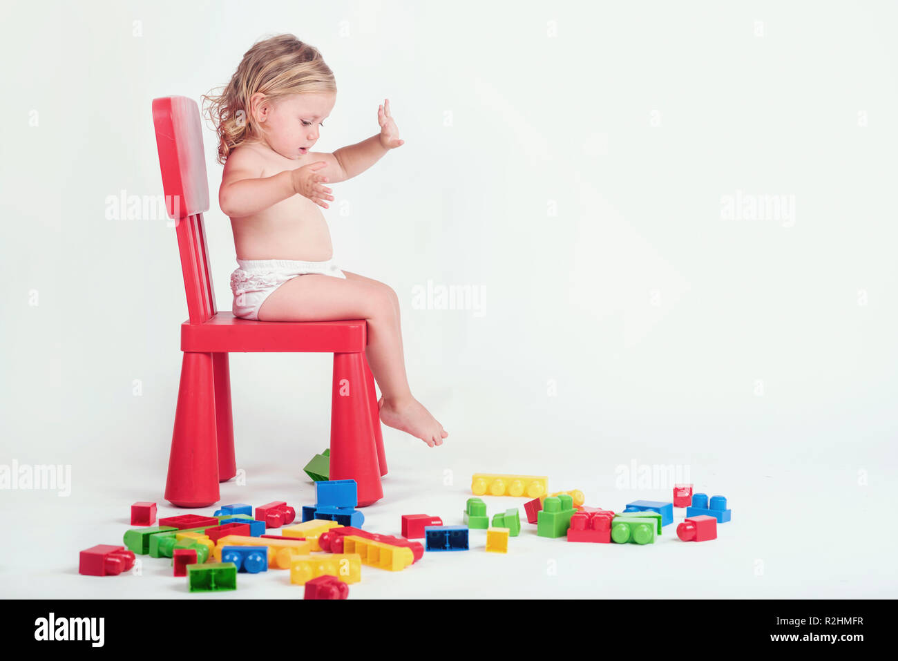 Bébé fille jouant avec des éléments de base sur fond blanc Banque D'Images