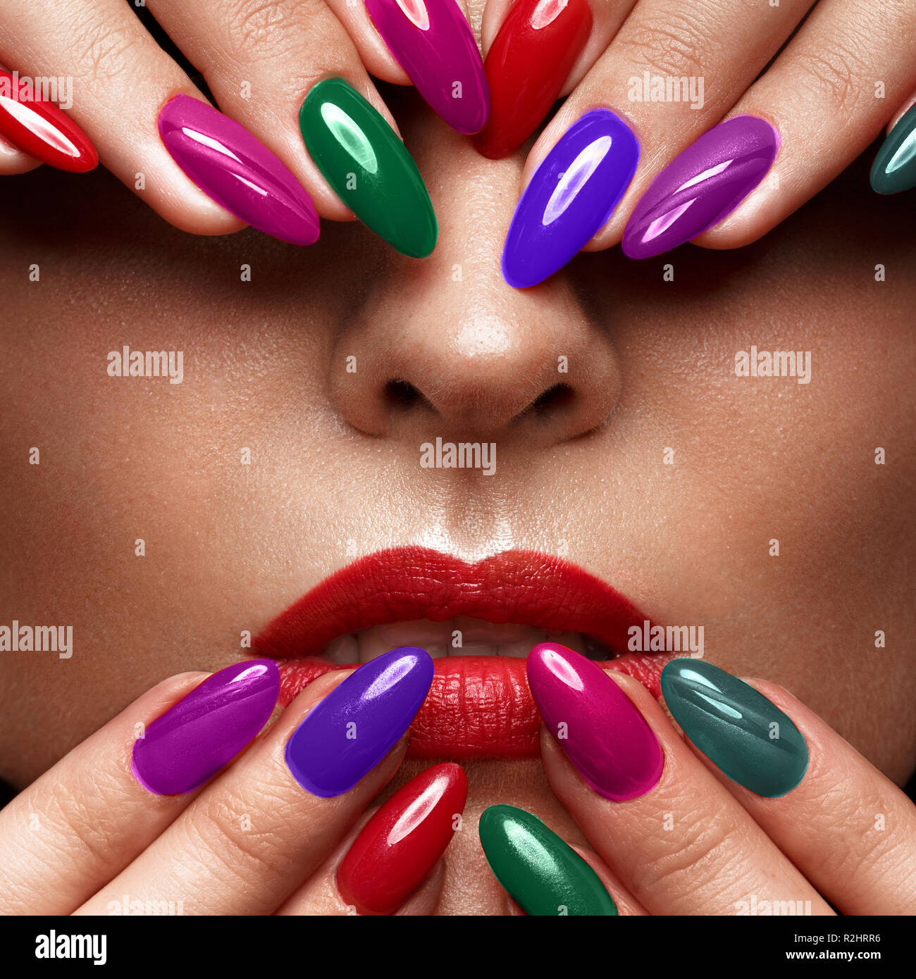 Belle fille avec un make-up classique et multi-couleur des ongles. Conception de manucure. Beauté Visage. Banque D'Images