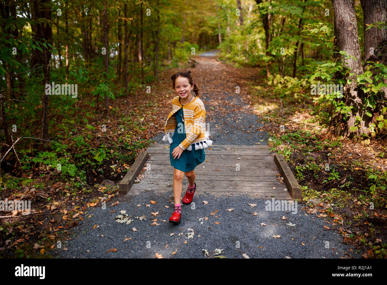 Fille courir à travers un petit pont sur un sentier dans une forêt, United States Banque D'Images