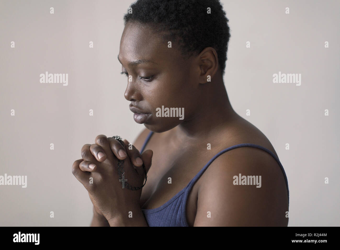 Femme en prière avec le chapelet sereine Banque D'Images