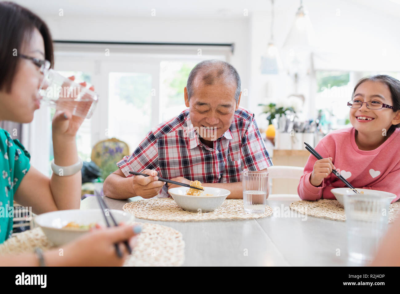 Multi-generation family eating noodles avec des baguettes à table Banque D'Images