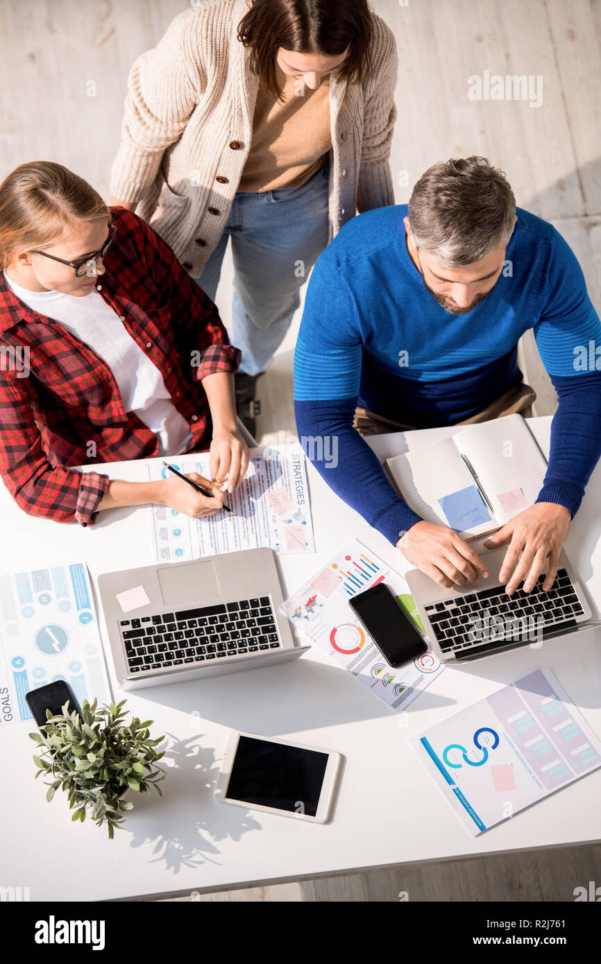 Les analystes réfléchis sérieusement occupé à travailler sur les documents de projet de marketing et d'analyse de données in Banque D'Images