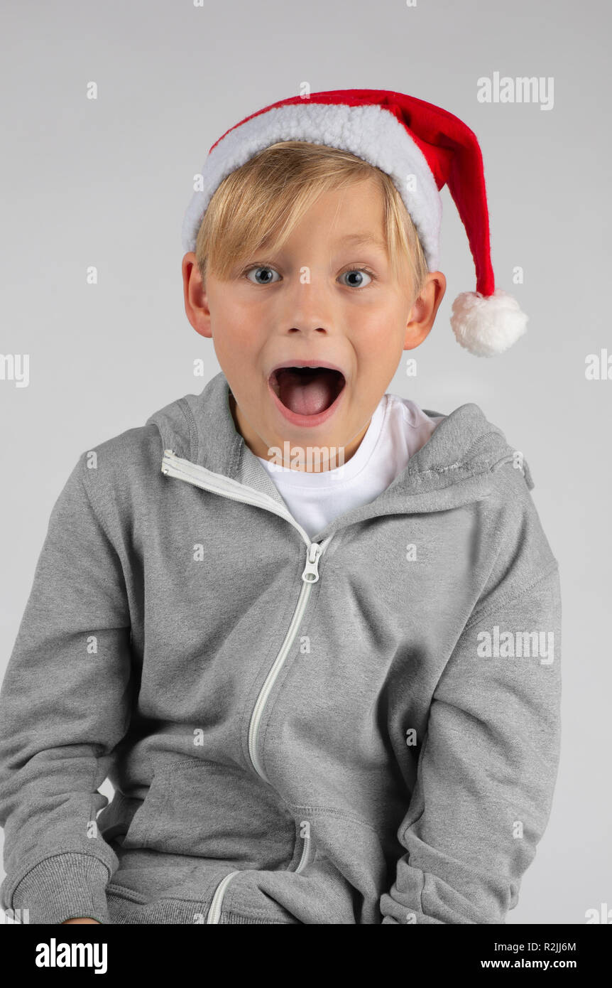 Petit garçon blond avec un chapeau de Père Noël est surpris avec la bouche  ouverte Photo Stock - Alamy