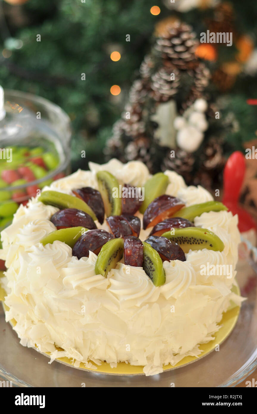 Le Chocolat Blanc Gateau De Fruit Avec Kiwi Prune Et Creme Fouettee Sur Le Dessus Et De Morceaux De Chocolat Autour Avec Des Decorations De Noel Photo Stock Alamy