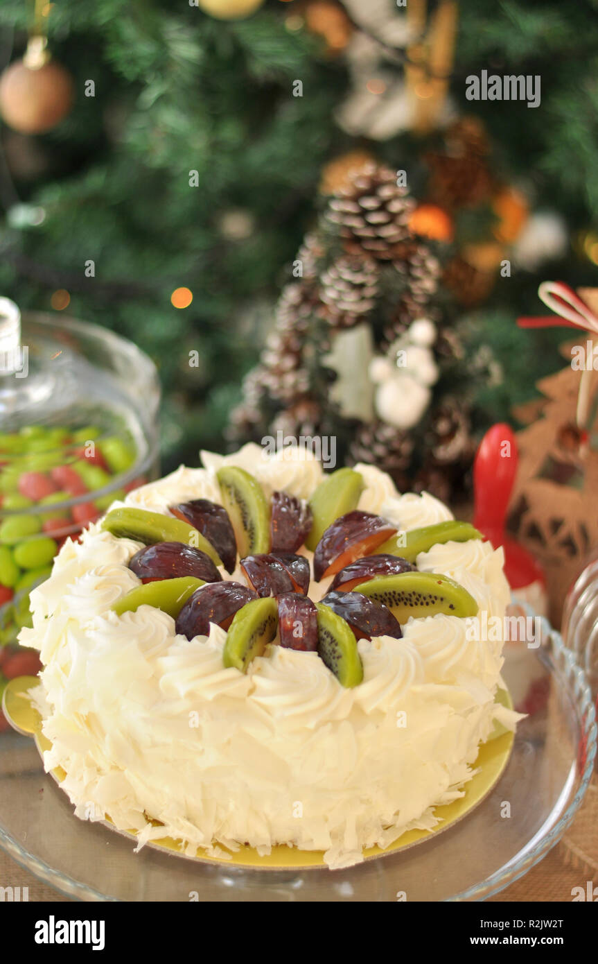 Le Chocolat Blanc Gateau De Fruit Avec Kiwi Prune Et Creme Fouettee Sur Le Dessus Et De Morceaux De Chocolat Autour Avec Des Decorations De Noel Photo Stock Alamy