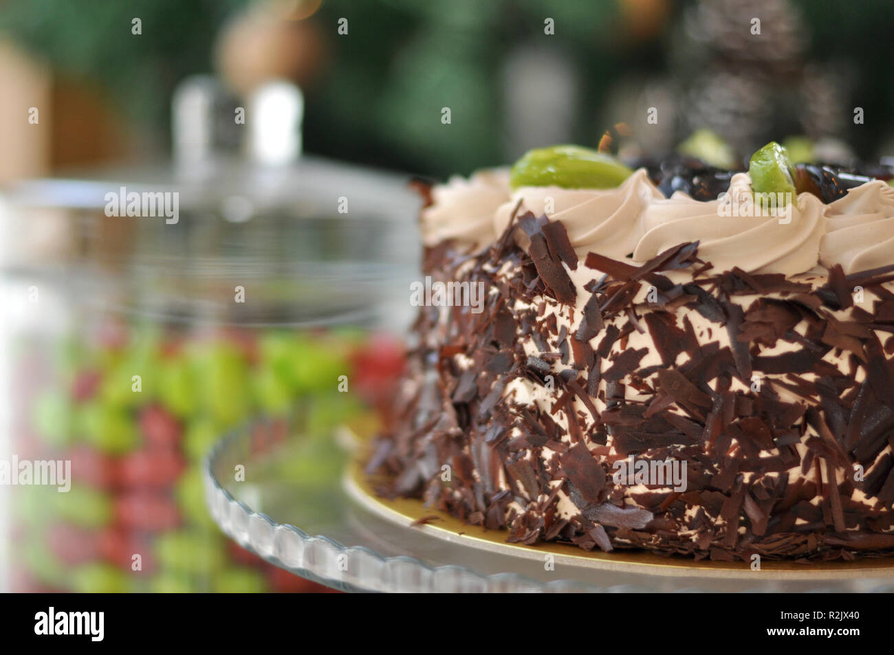 Gâteau aux fruits chocolat avec kiwi, prune et crème fouettée sur le dessus et de morceaux de chocolat autour avec des décorations de Noël Banque D'Images