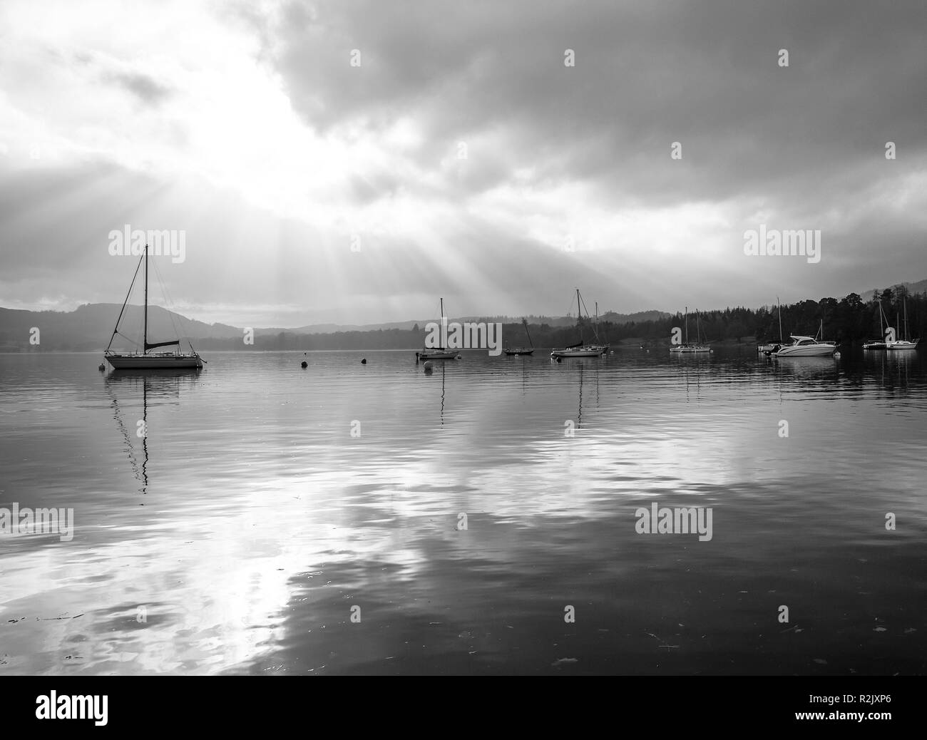 Image en noir et blanc de yachts et bateaux amarrés près de Ambleside à Waterhead sur le lac Windermere avec rayons de soleil Cumbria England Royaume-Uni Banque D'Images